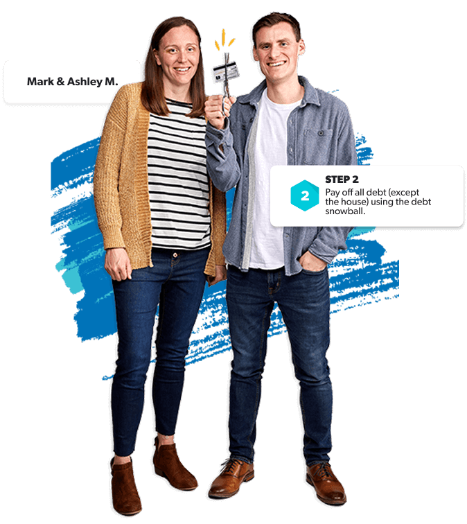 Couple smiles as they cut up a credit card—ready to ditch debt and start the debt snowball.